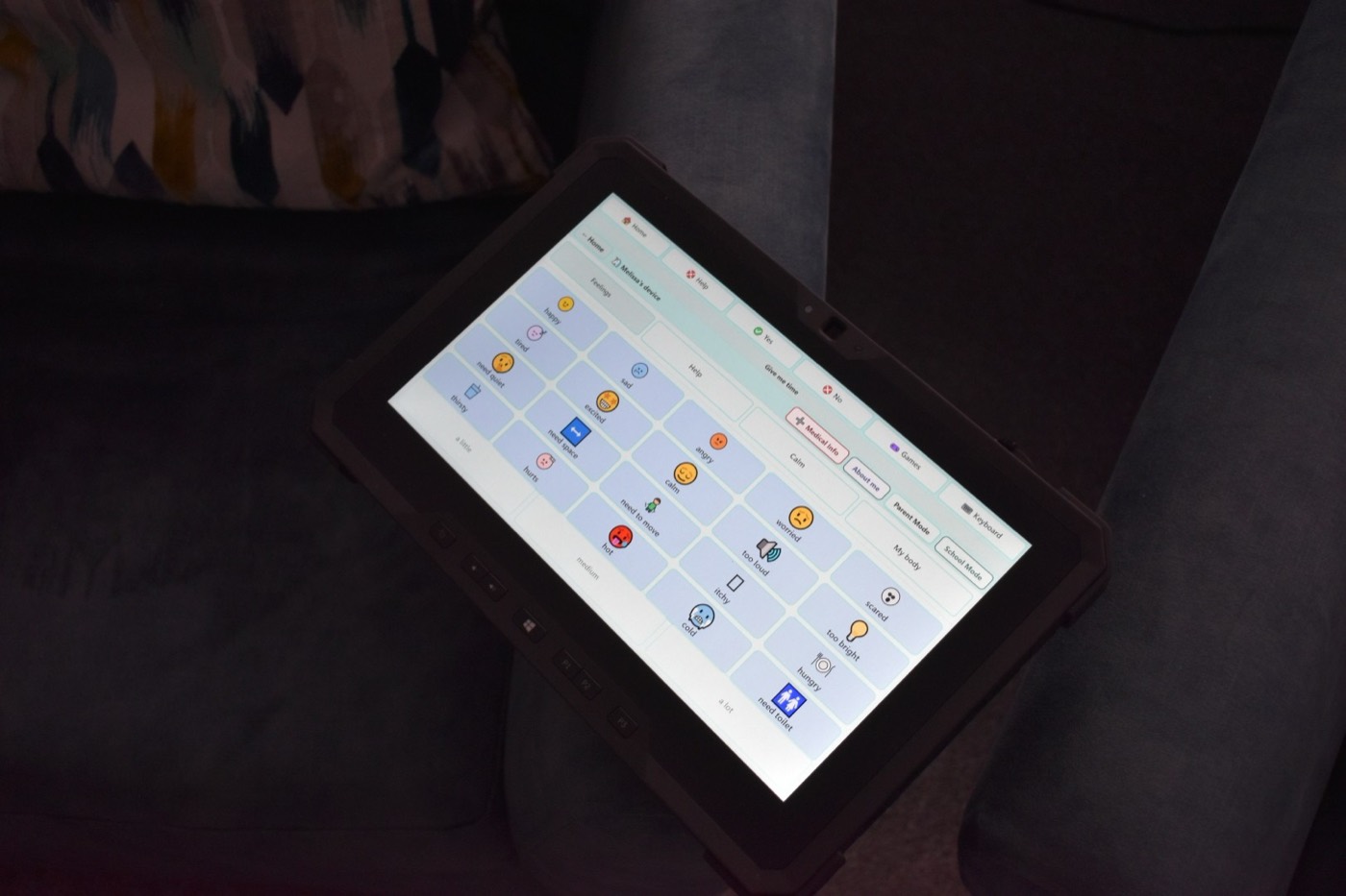 The Feelings page on a tablet resting on the arm of a sofa in a dim room
